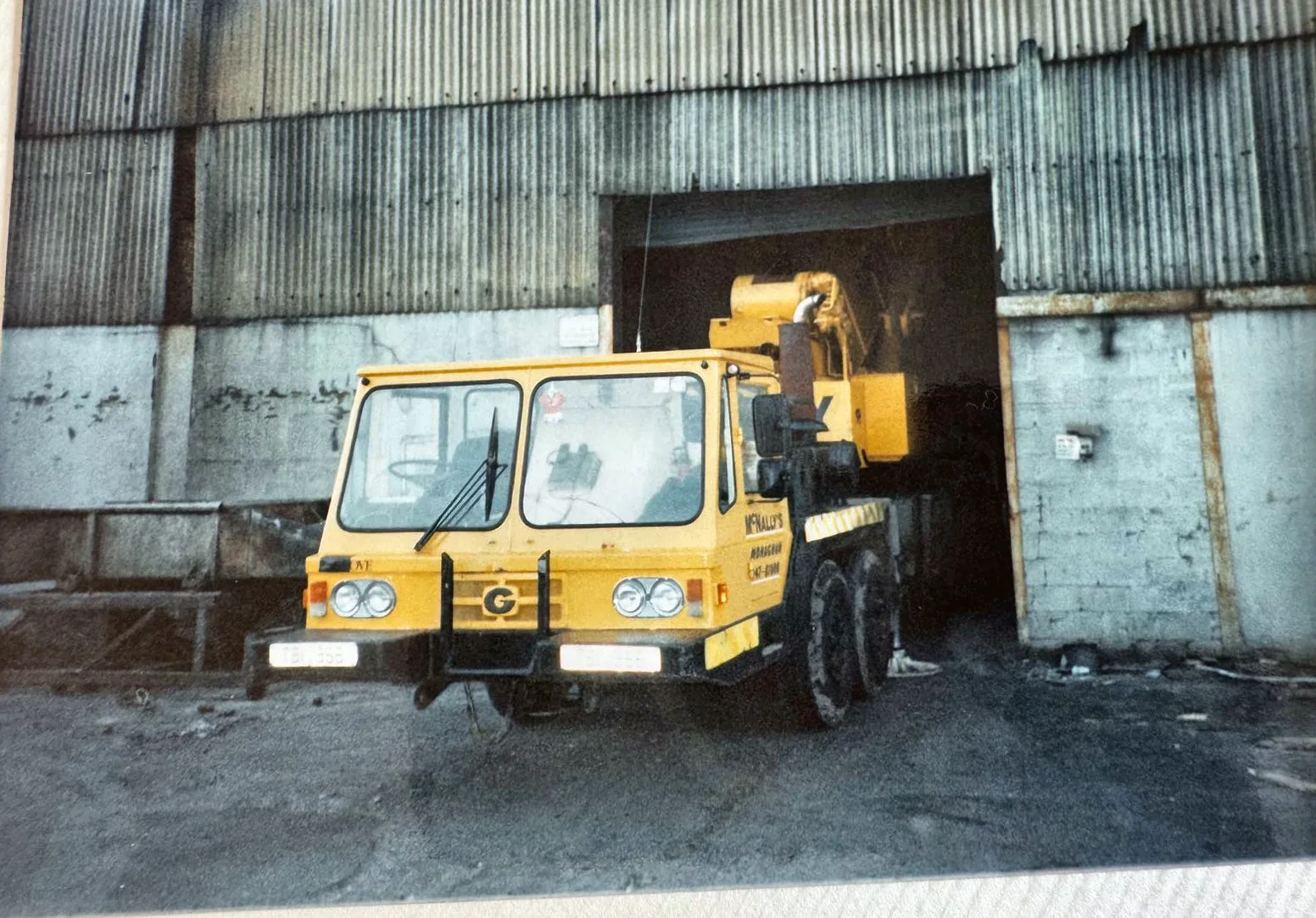 Archive photograph of a McNally’s mobile crane parked outside a corrugated shed