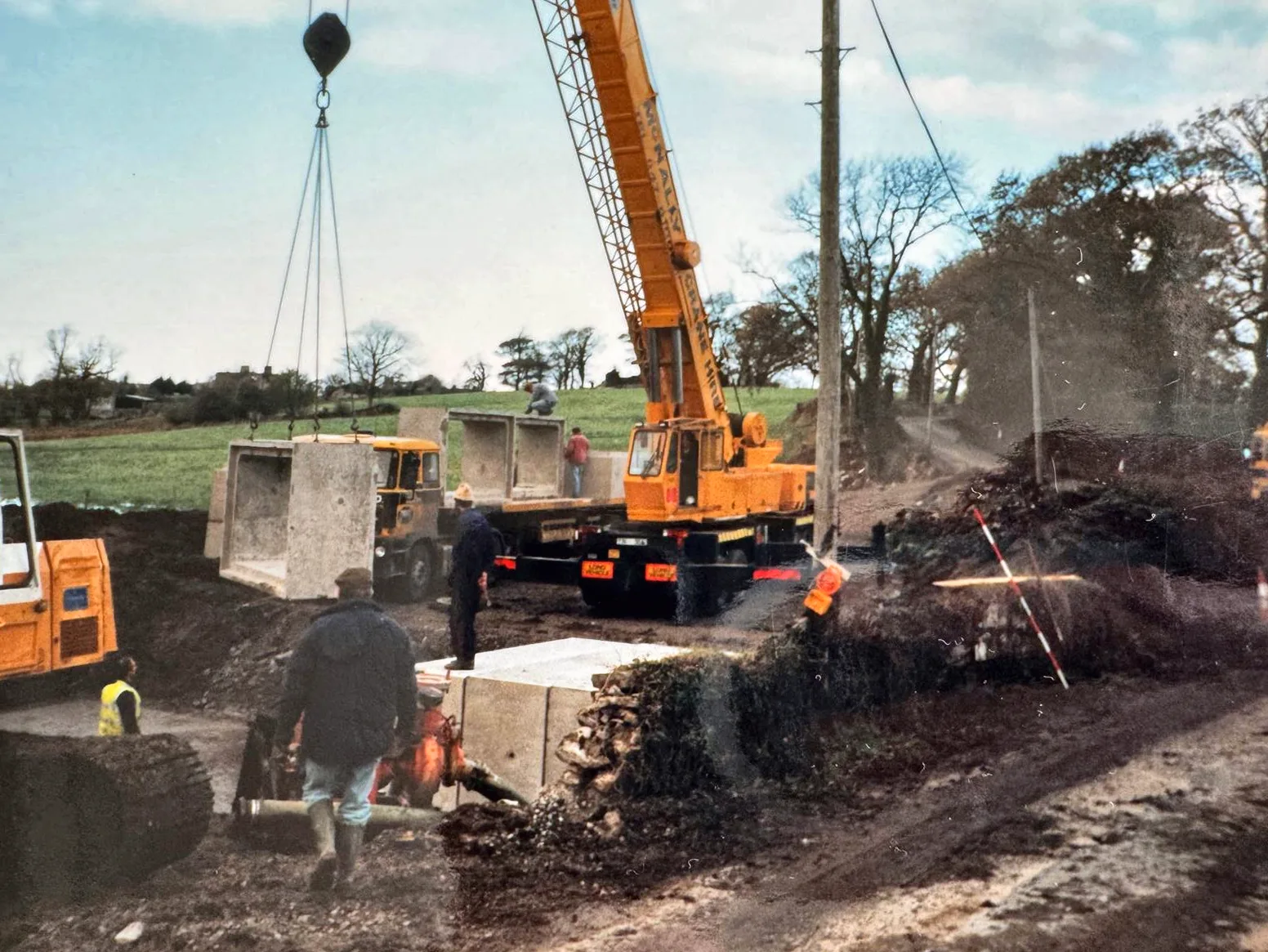 Archive photograph of a McNally’s crane lifting precast panels with the crew at work