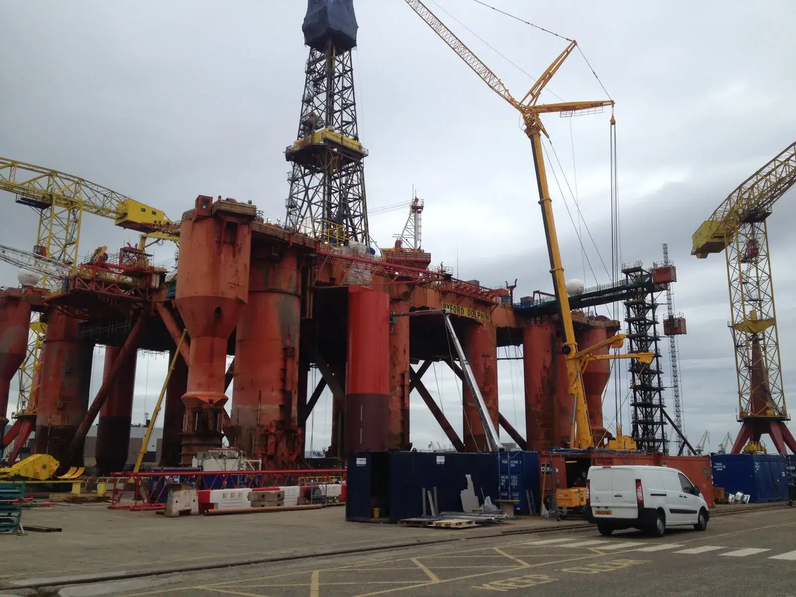 Crawler crane working beside a semi-submersible drilling rig on the quayside