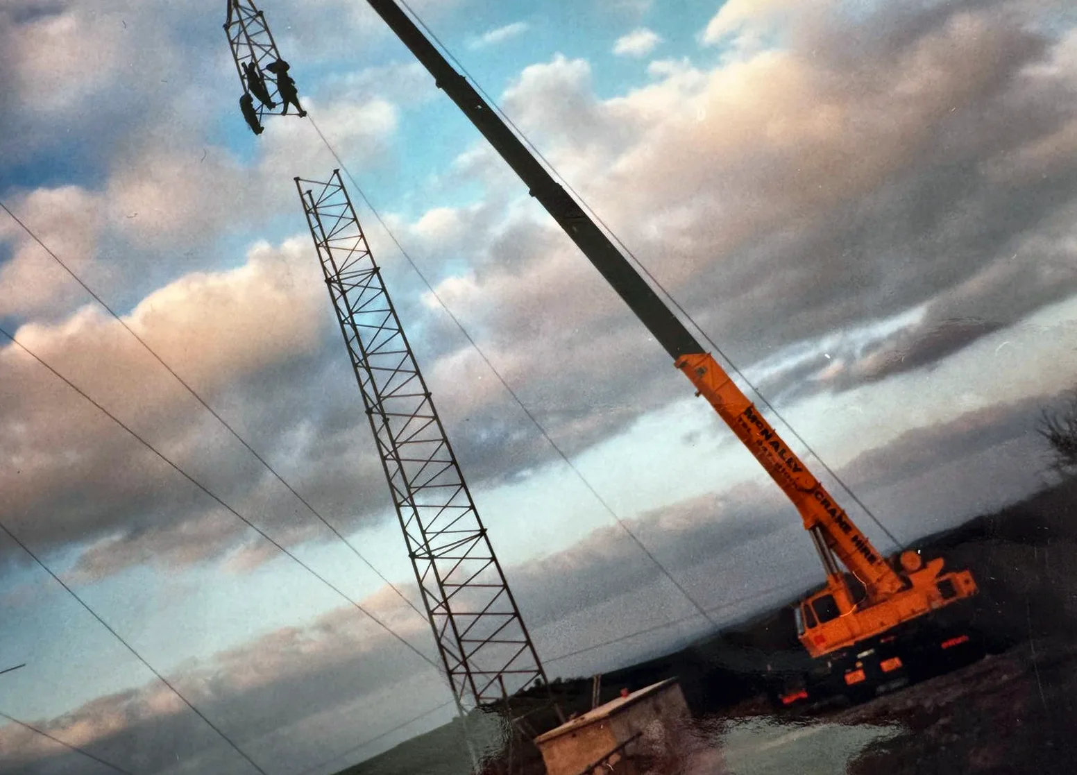 Archive photograph of a McNally’s lattice boom and crane over the river at sunset