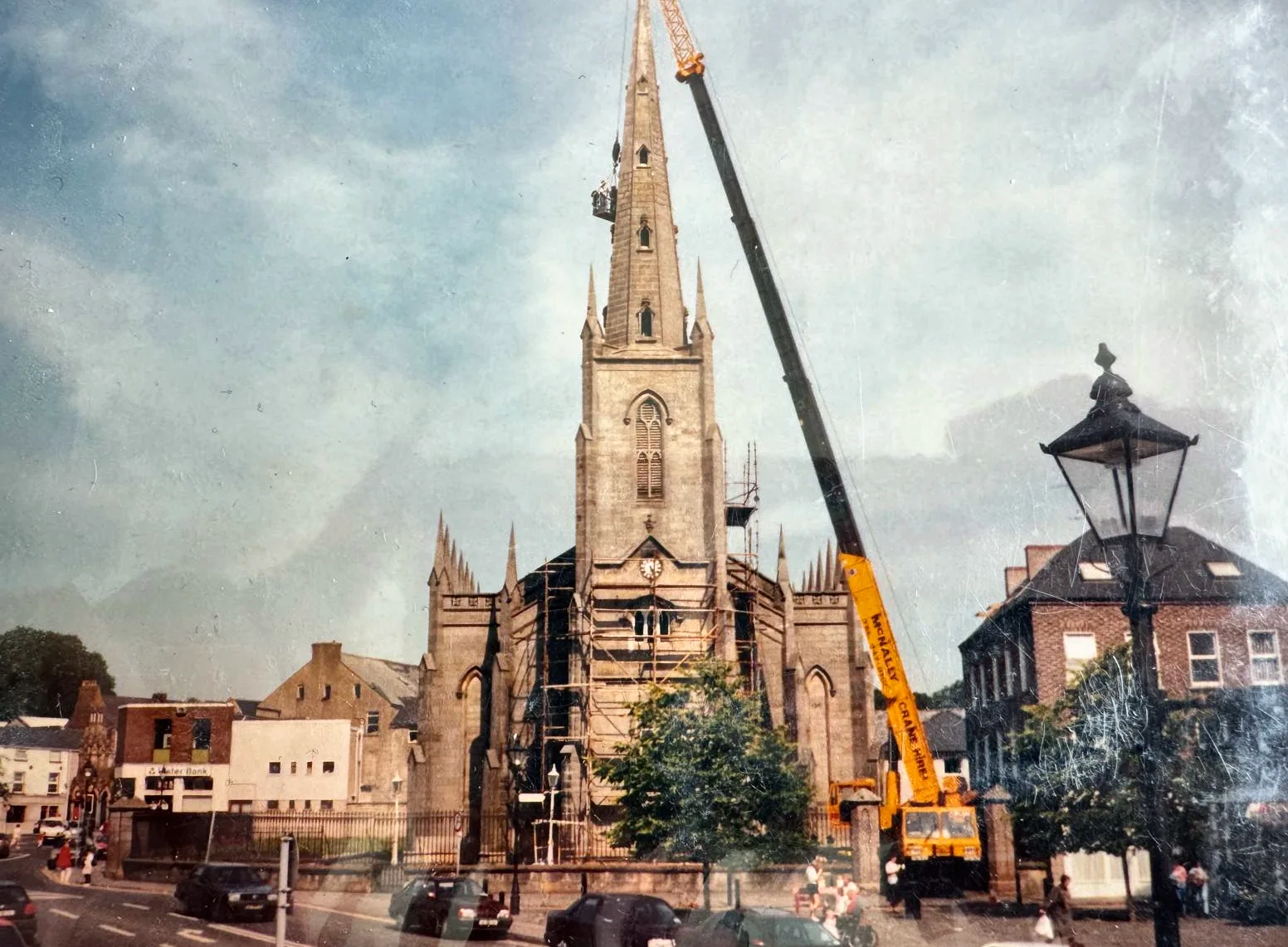 Archive photograph of a McNally’s mobile crane beside a church spire in town