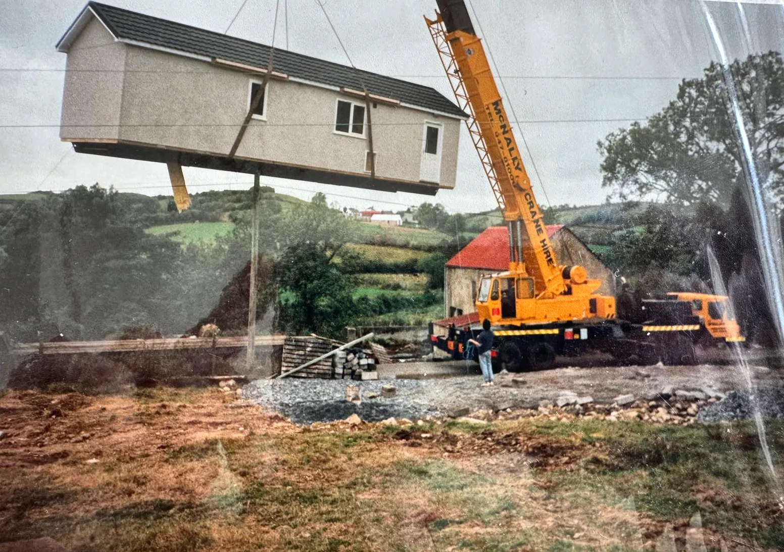 Archive photograph of a McNally’s crane lowering a prefabricated building into place