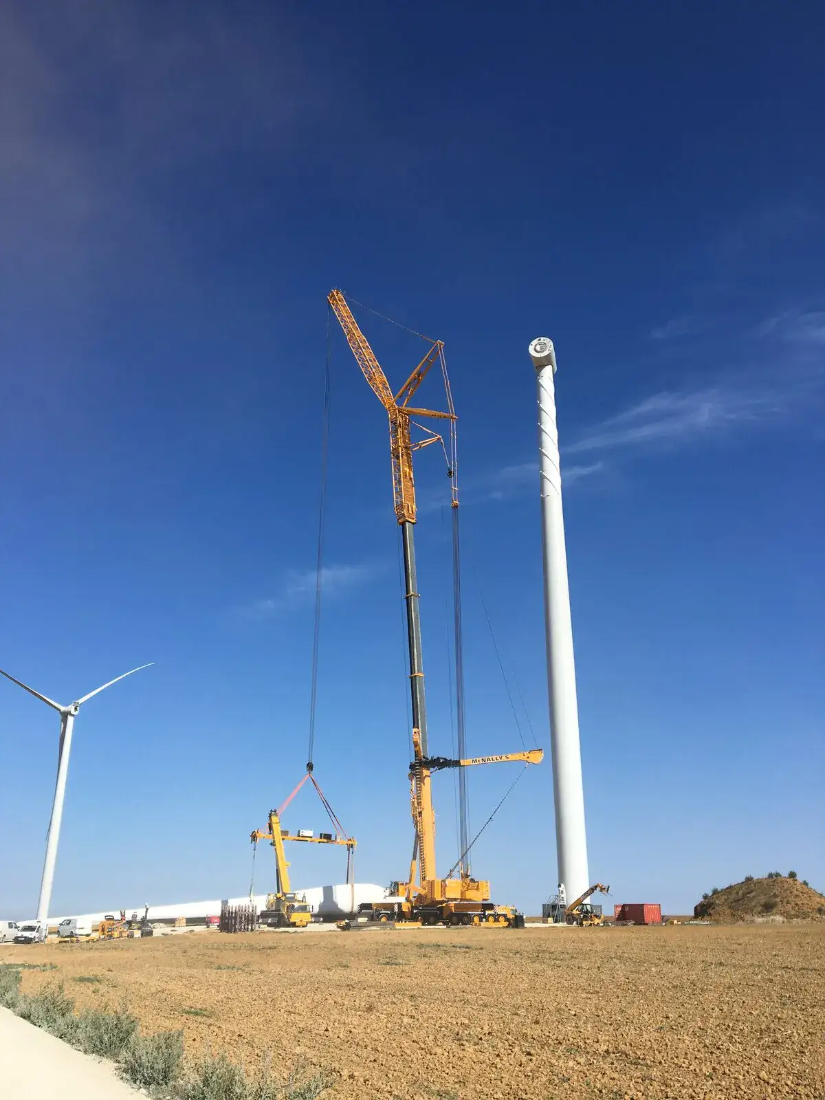 McNally’s crane beside a wind turbine tower against a clear blue sky
