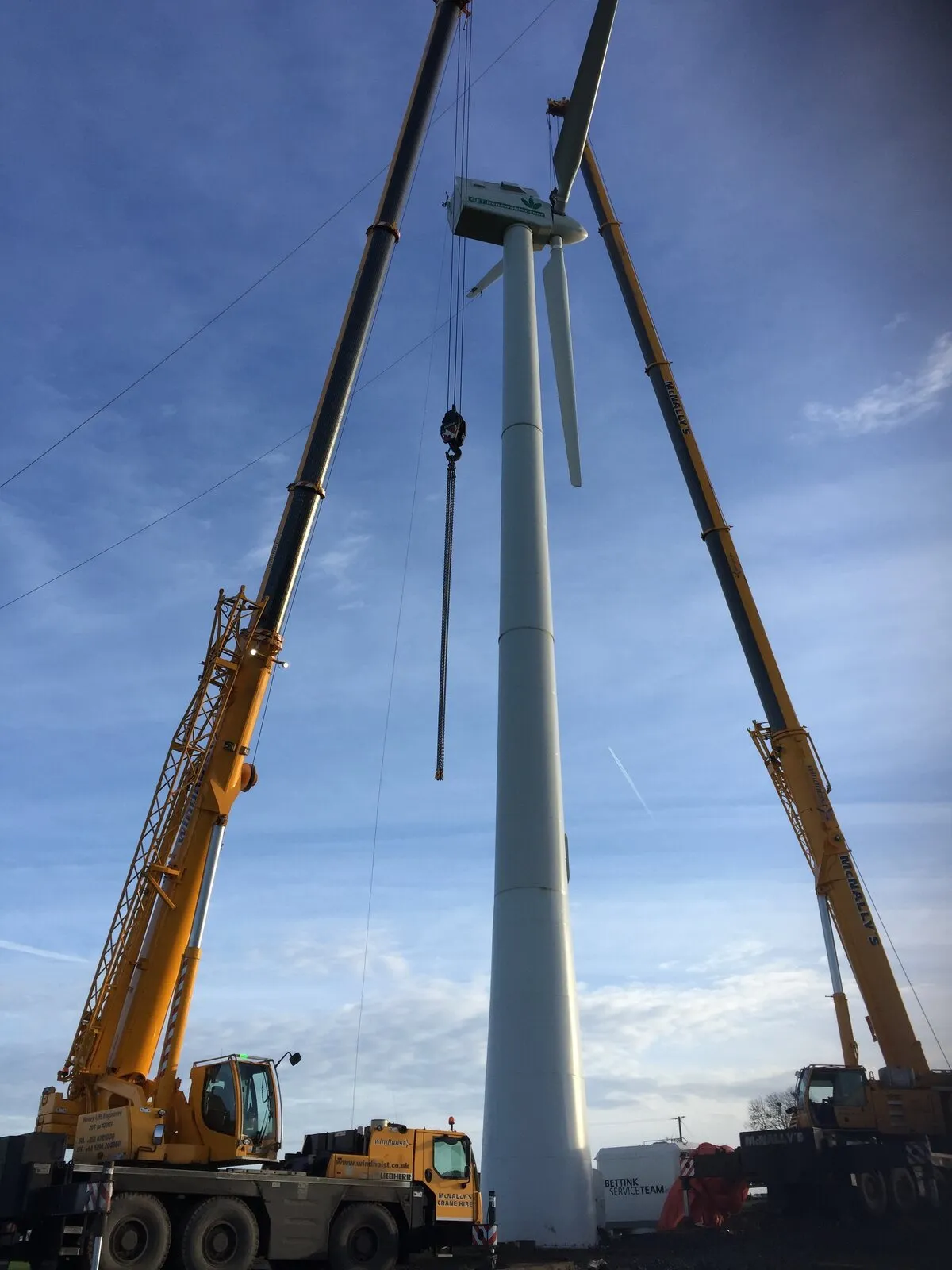 Looking up a wind turbine tower between two all-terrain cranes