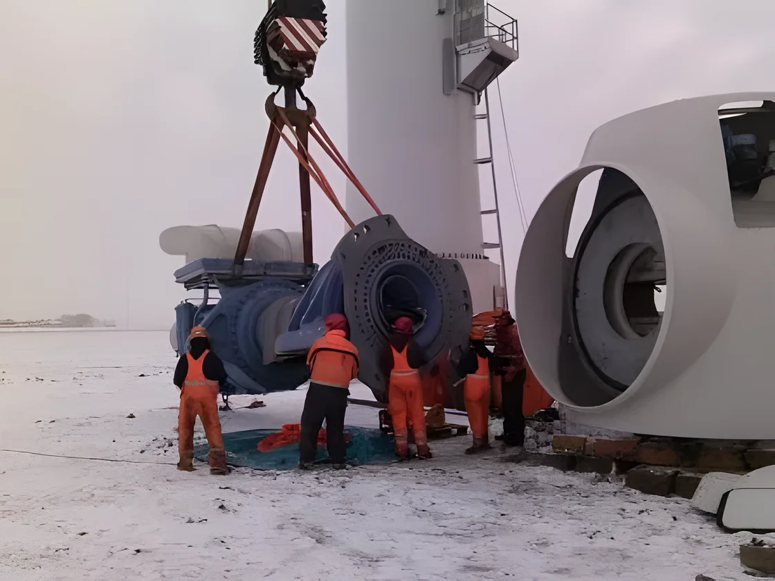 Crew preparing a turbine hub for lifting in the snow at Zuidlob wind farm, the Netherlands